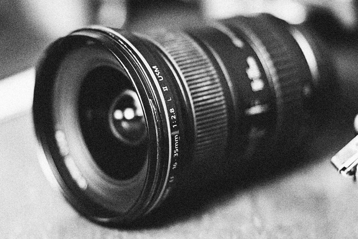 A monochrome close-up of a wide-angle camera lens with vintage appeal.